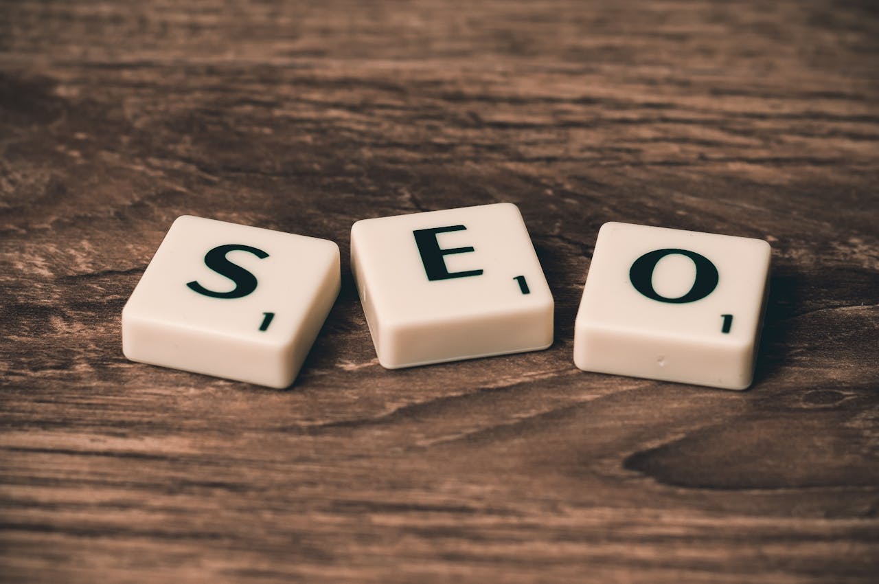 contact-img Scrabble tiles spelling 'SEO' on a wooden surface. Ideal for digital marketing themes.
